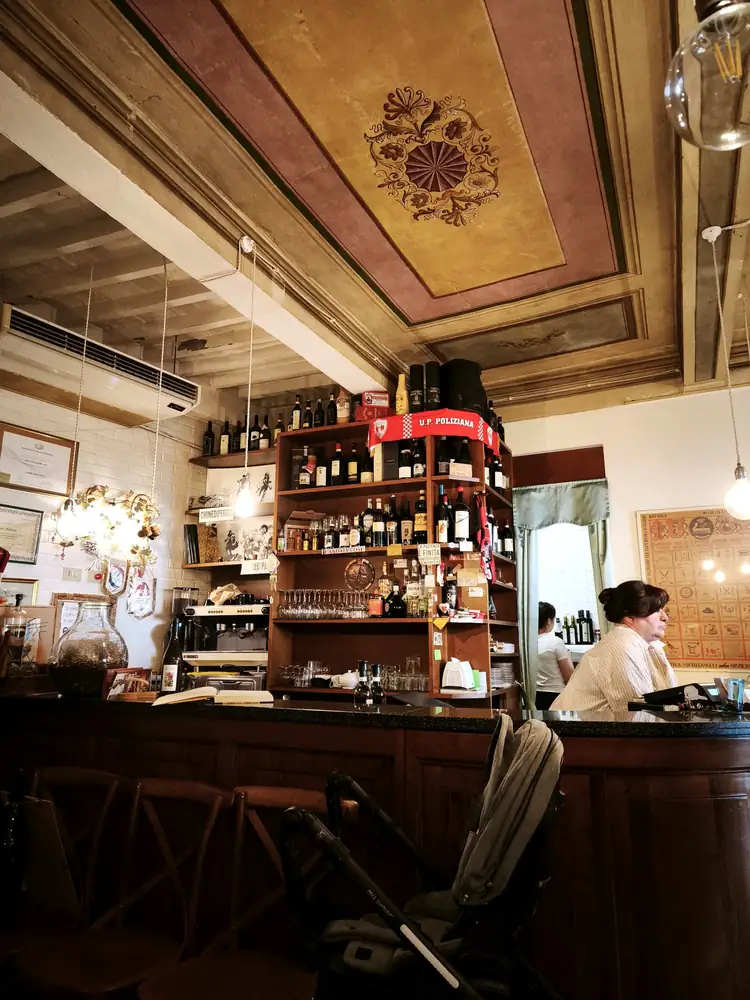 Il bancone con la bilancia rossa d'epoca e lo scaffale di bottiglie
