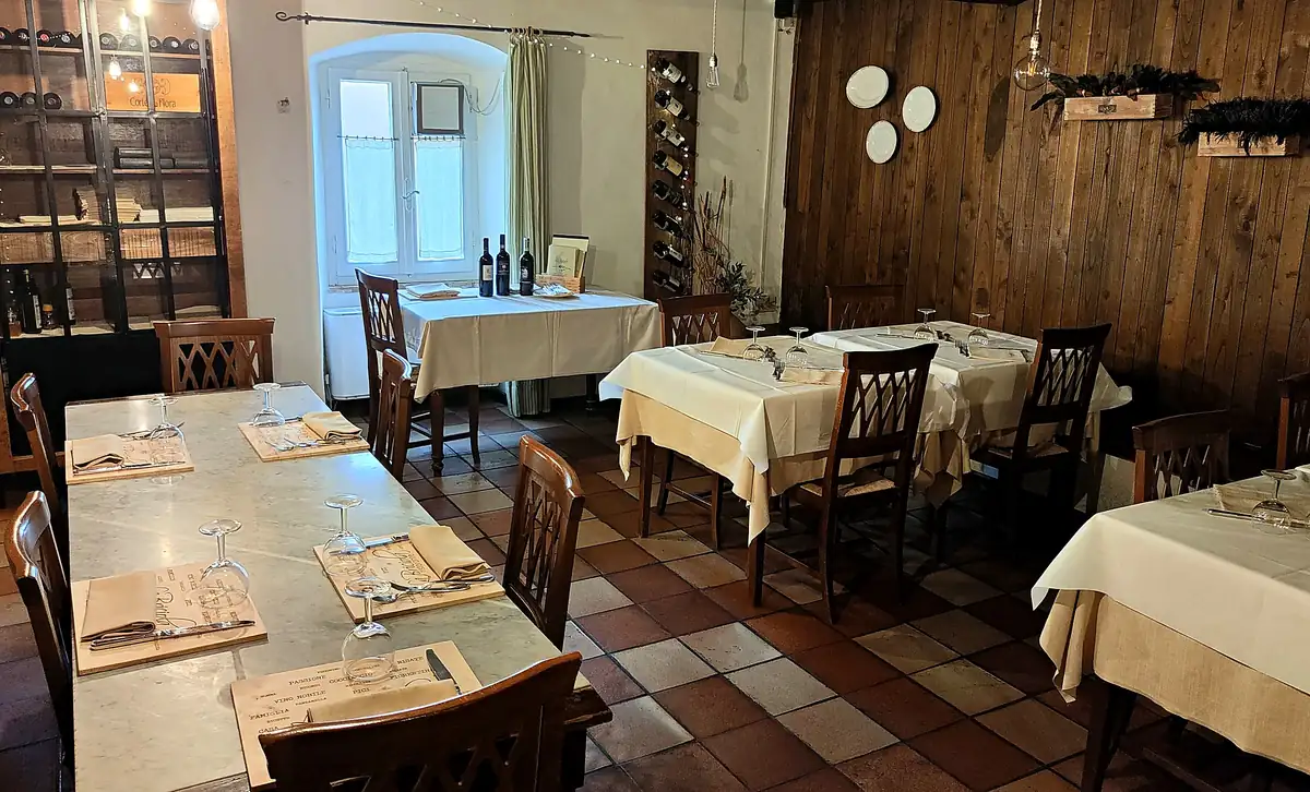 La sala apparecchiata prima del servizio, sotto le volte in mattoni