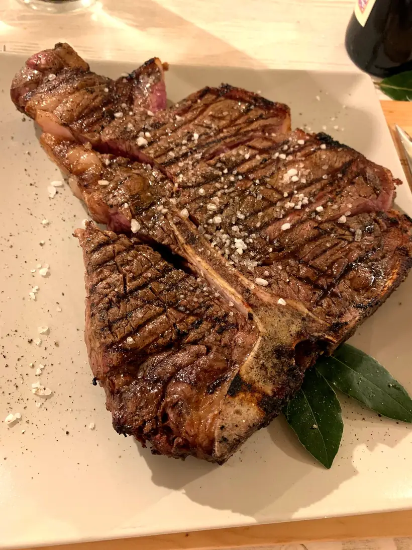 Una Fiorentina servita al tavolo, tagliata sull'osso
