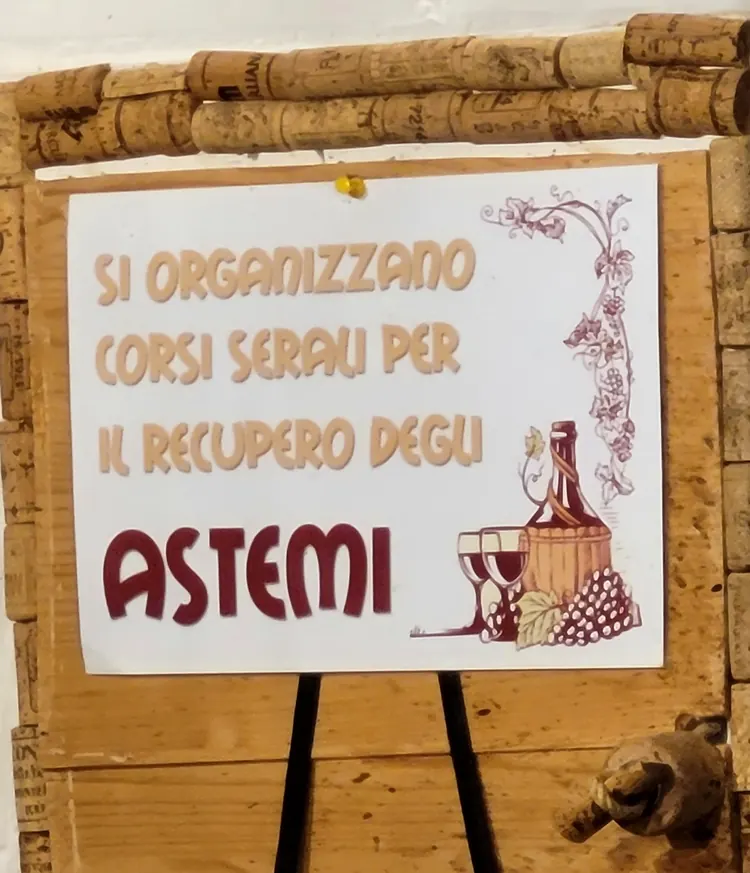 Cartello incorniciato di tappi di sughero: si organizzano corsi serali per il recupero degli astemi