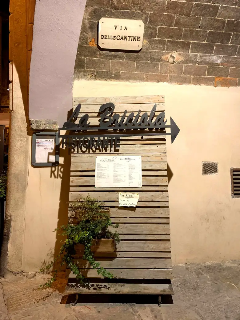 Il cartello della via e l'insegna del ristorante nello stesso inquadratura, in Via delle Cantine