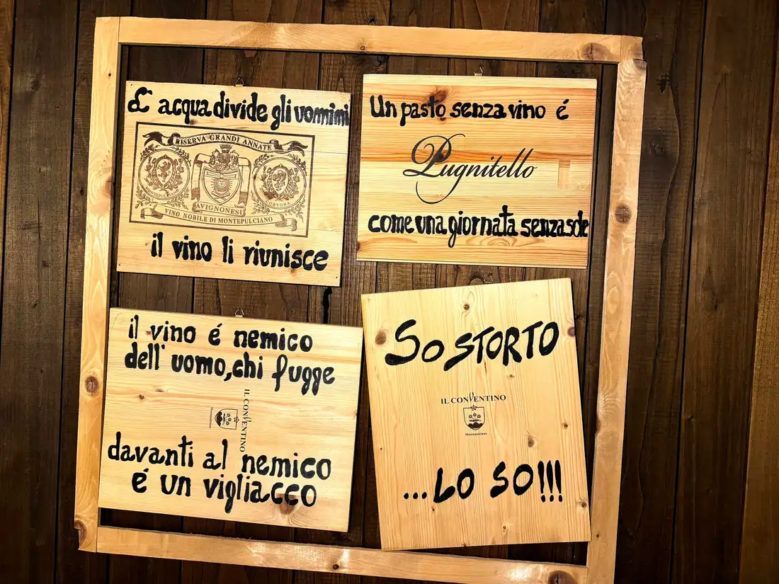 La parete con le targhe di proverbi sul vino, in sala